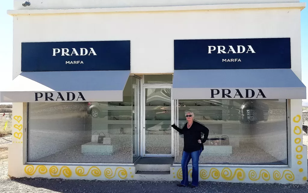 woman posing in front of a designer store.
