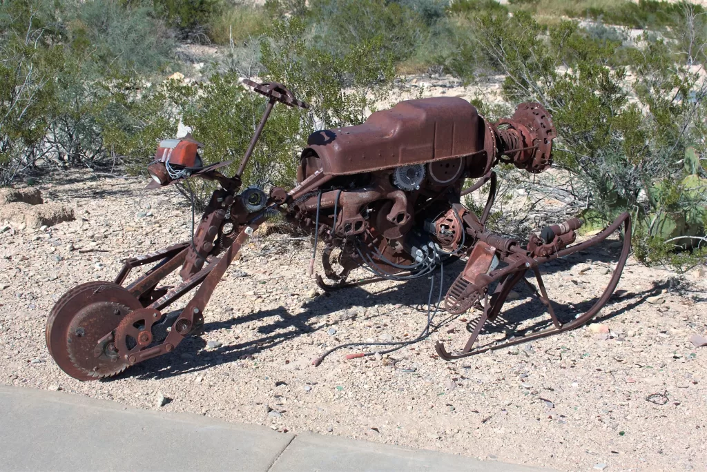 rusted vintage motorcycle in a desert garden.