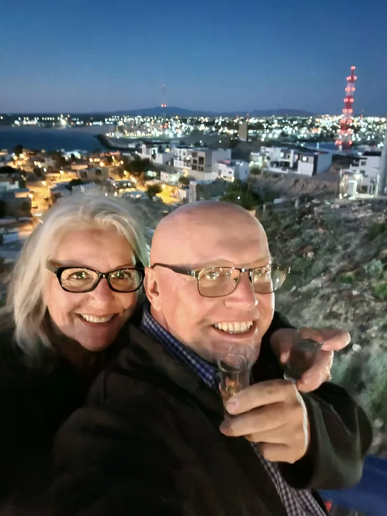 Rocky Point Mexico Rv Parks: Ultimate Guide 2025 14 Couple posing with a scenic view of the city below.
