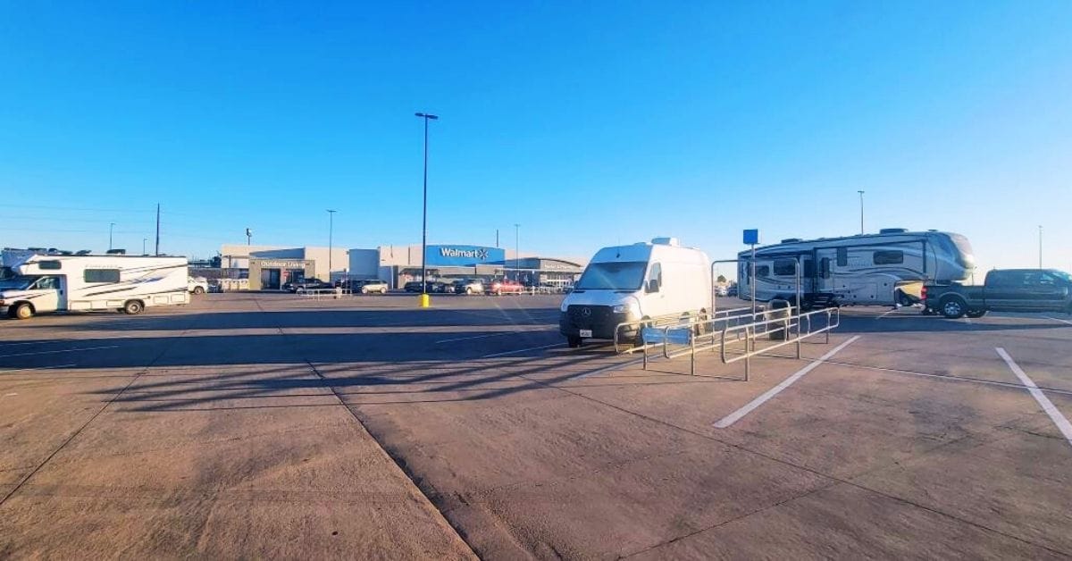 Overnight RV Parking at Walmart and Other Stores RVs and vans parked along the edge of a Walmart lot on a clear day, showing typical overnight parking for travelers.