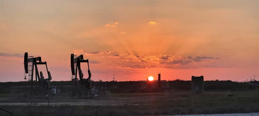 Gate Guarding: Work Camping Jobs For Full-Time Rvers 2024 12 Orange sunset over oil pumps.