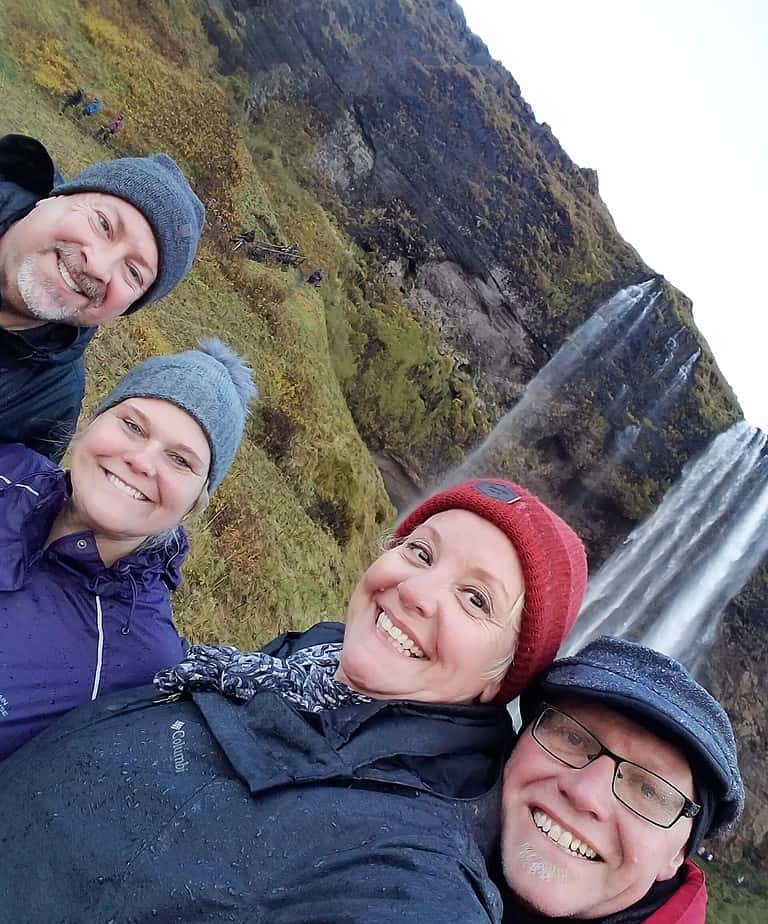 Group of friends posing in front of a waterfall.