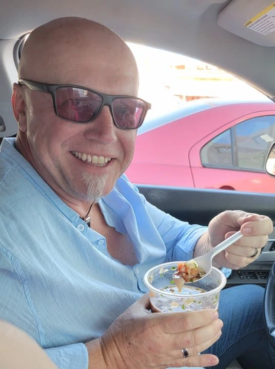 Man eating ceviche in a car.