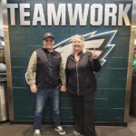 Best Campgrounds Near Philadelphia, Pa For 2025 29 Two individuals standing in front of a 'teamwork' sign with a philadelphia eagles logo, symbolizing unity and sportsmanship, at a presumably team-related venue