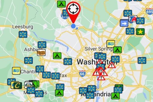Rv Apps: Which Ones Do You Need? 5 This image shows a map of the washington, d. C. Area with various icons overlaid, indicating points of interest such as camping sites (green tent icons), shopping locations (blue icons with flowers), warning symbols (red triangle with an exclamation mark), and other specific locations or services. A large red pin with a target symbol at the top center marks a significant location near the center of the map. Surrounding areas like leesburg, ashburn, and alexandria are also labeled on the map.