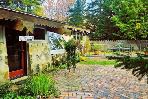 The Ultimate Acadia National Park Itinerary For 2025: Your Perfect 3-Day Plan 19 Bartlett estate winery tasting room, a rustic stone building with a brick courtyard, outdoor seating, and lush greenery