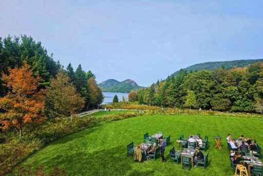 The Ultimate Acadia National Park Itinerary For 2025: Your Perfect 3-Day Plan 8 Outdoor dining at jordan pond house in acadia, with green lawn seating, fall foliage, and a view of jordan pond and the bubbles.