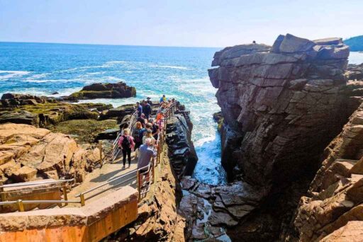 The Ultimate Acadia National Park Itinerary For 2025: Your Perfect 3-Day Plan 6 Visitors at thunder hole in acadia watch waves crash into a narrow rocky inlet, creating a dramatic splash against the rugged cliffs.