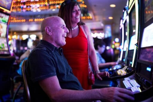 30 Best Things To Do In Batavia, Ny In 2025 18 Smiling couple enjoying slot machines at batavia downs gaming in ny, surrounded by colorful lights and a lively casino atmosphere.