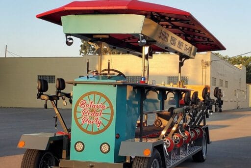30 Best Things To Do In Batavia, Ny In 2025 19 Bright blue batavia pedal party vehicle with red canopy, parked under golden evening light, ready for a group ride around town.
