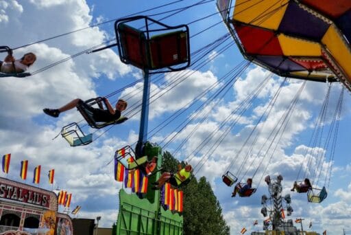 30 Best Things To Do In Batavia, Ny In 2025 16 Kids ride colorful swings under a sunny sky at the genesee county fair in batavia, ny, with carnival flags and rides in view.