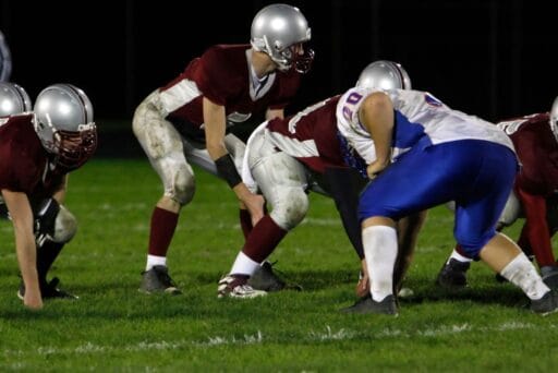 30 Best Things To Do In Batavia, Ny In 2025 17 High school football players line up for a play under stadium lights, with one team in maroon and the other in blue and white uniforms.