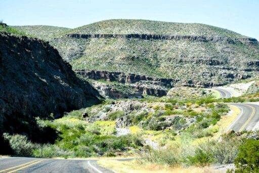 11 Fun Things To Do In Terlingua You Can’t Miss In 2025 11 Winding river road in west texas curves through rugged desert canyons and hills covered in sparse greenery.