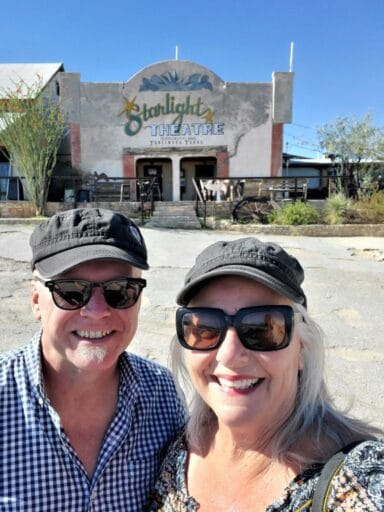 11 Fun Things To Do In Terlingua You Can’t Miss In 2025 25 Smiling couple in sunglasses and hats pose in front of the historic starlight theatre in terlingua, texas.