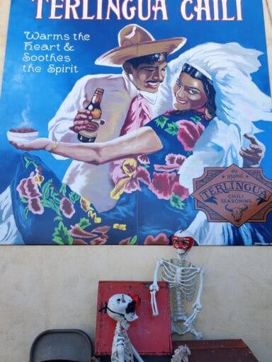 11 Fun Things To Do In Terlingua You Can’t Miss In 2025 19 Colorful mural for terlingua chili with a festive couple dancing, beer in hand; skeletons posed below add quirky flair.