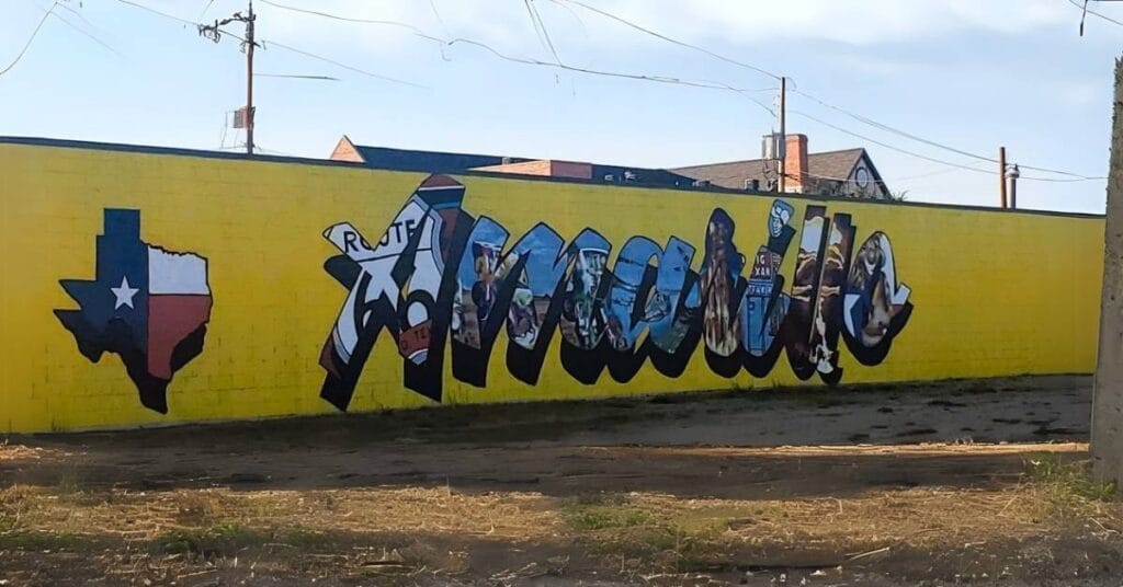 Yellow amarillo mural with bold lettering filled with local images, including route 66, cowboys, and texas icons.
