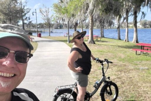 The Complete Guide To Full-Time Rv Living 7 Smiling couple near a lake with electric bike on a sunny day at a park