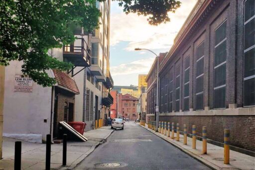 The Hidden Entrance To Ranstead Room: A Speakeasy Roadside Attraction In Philly A narrow philadelphia alley at sunset leads to the hidden entrance of the ranstead room speakeasy, marked by a discreet door.