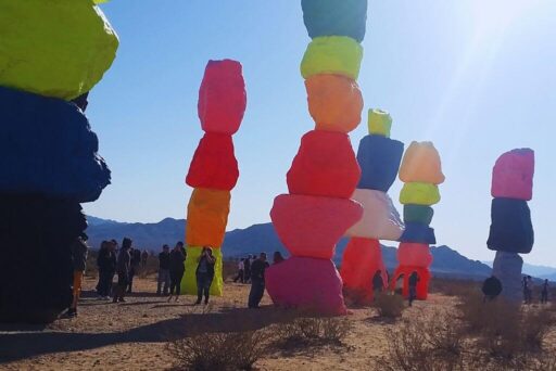 Seven Magic Mountains: A Neon Landmark Near Las Vegas Visitors walk among towering stacks of neon-painted boulders in the desert at a colorful roadside attraction