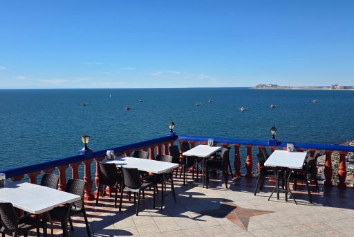 Outdoor terrace seating at la casa del capitan overlooking the ocean in puerto peñasco with white tables and chairs facing a wide blue sea view. This scenic restaurant setting shows one of the best places to relax and enjoy coastal views while exploring things to do in puerto peñasco.