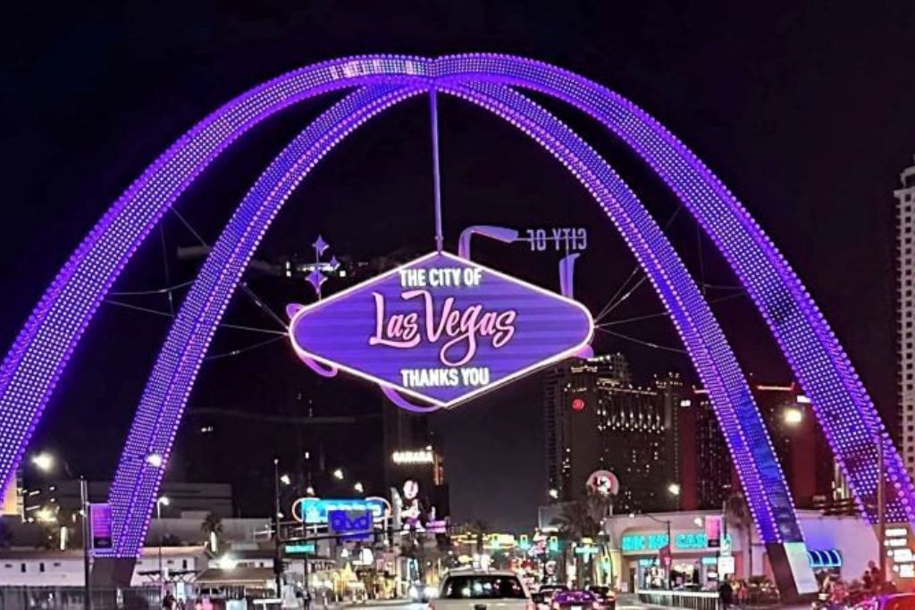 Las vegas strip at night with illuminated arch and "the city of las vegas" sign above busy traffic on a 5 day itinerary.