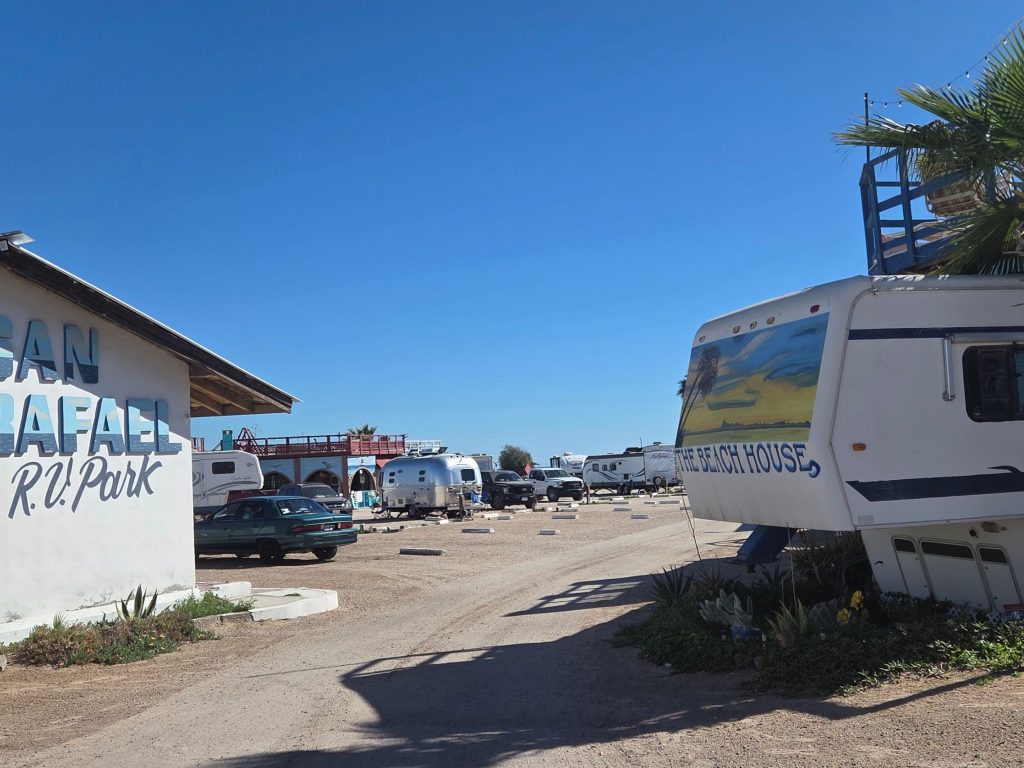 Entrance of san rafael rv park in rocky point mexico with painted sign rvs parked inside and beachside camping atmosphere.