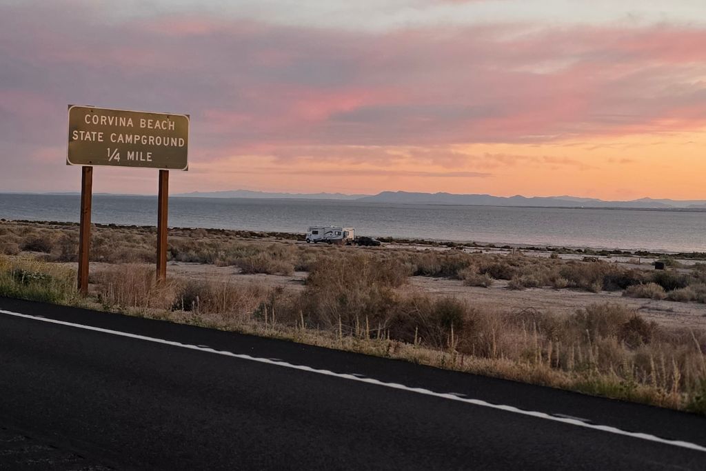 Visiting The Salton Sea: California’s Strangest Desert Lake 4 Sunset beside the salton sea near the corvina beach campground sign and an empty desert roadside.