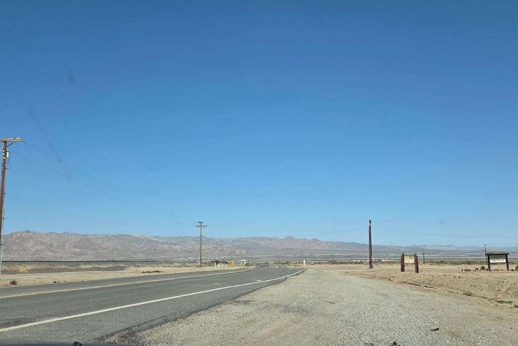 Visiting The Salton Sea: California’s Strangest Desert Lake 11 Empty desert highway leading toward the salton sea beneath a vast blue california sky.