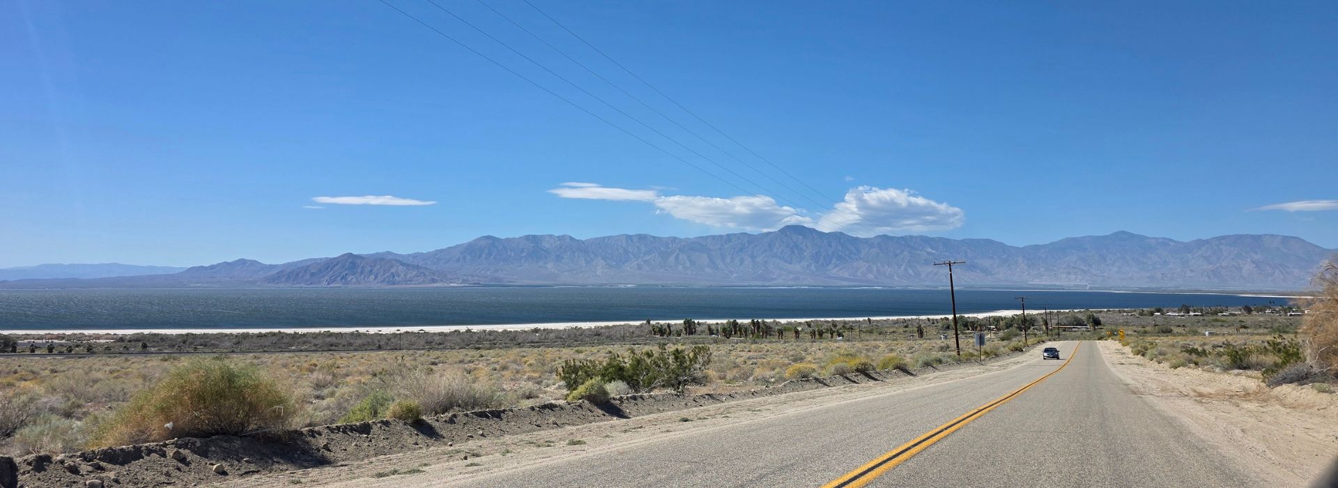 Salton Sea Desert Road View in California Desert road leading toward the Salton Sea with mountains and blue sky in Southern California.