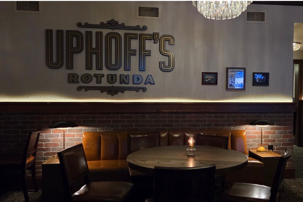 Wisconsin Dells For Adults: Beyond The Waterparks 15 Uphoffs rotunda speakeasy with leather seating around a round table beneath the large wall sign reading