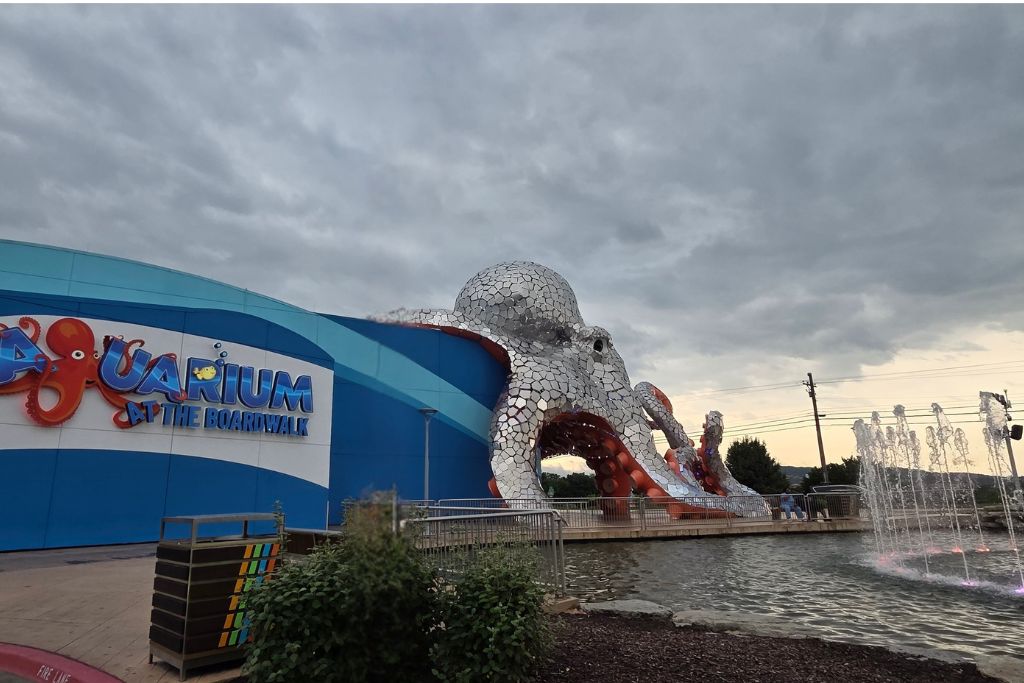 Is Branson Worth Visiting? Our Thoughts After Three Days 10 Giant octopus entrance at the aquarium at the boardwalk in branson with colorful fountains and dramatic evening clouds. One of the newer attractions we visited while deciding if branson is worth visiting.