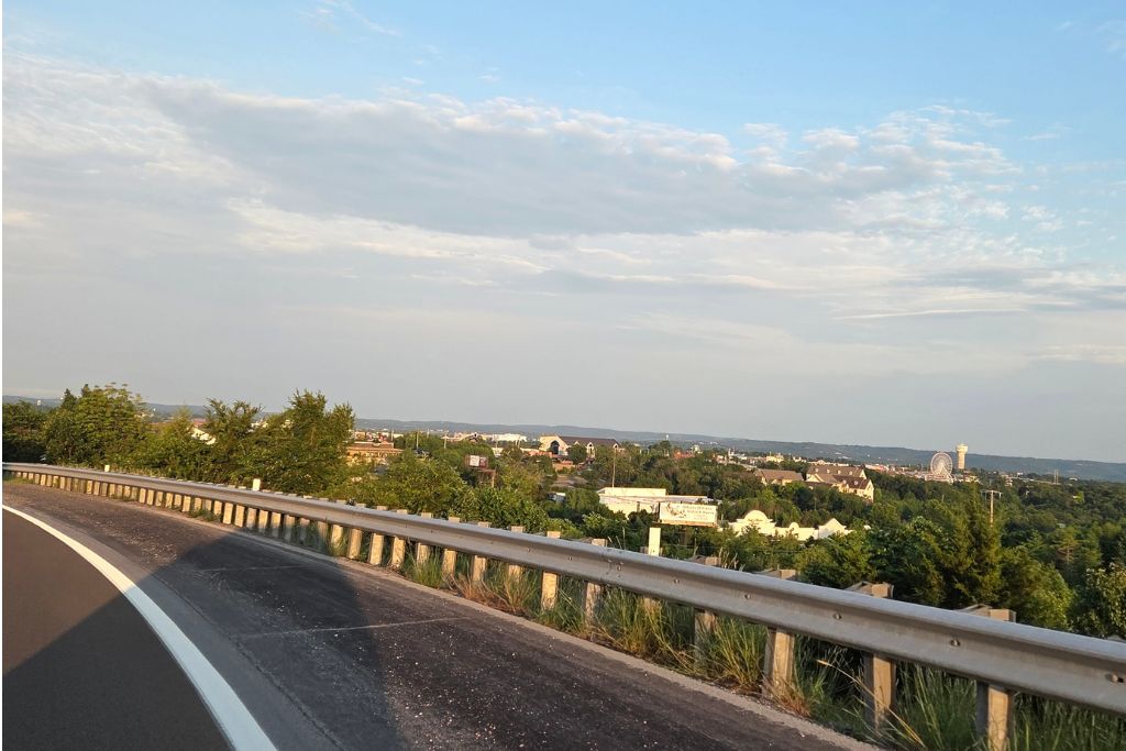 Is Branson Worth Visiting? Our Thoughts After Three Days 1 A winding road overlooks branson with the ferris wheel and ozark hills visible in the distance. After years of hearing about branson, this scenic view marked the beginning of our first visit.