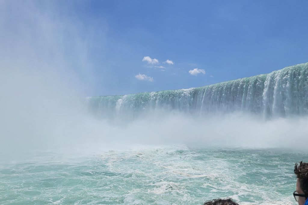 Is Niagara Falls Worth Visiting? What We Think After Several Visits 9 Horseshoe falls towers above the churning niagara river as maid of the mist approaches the wall of falling water. Thick mist fills the air and partially obscures the curve of the falls giving passengers an up close view of its power.