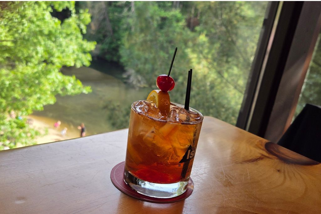 Wisconsin Dells For Adults: Beyond The Waterparks 13 Wisconsin old fashioned garnished with an orange slice and cherry at ishnala supper club with the wooded shoreline below.