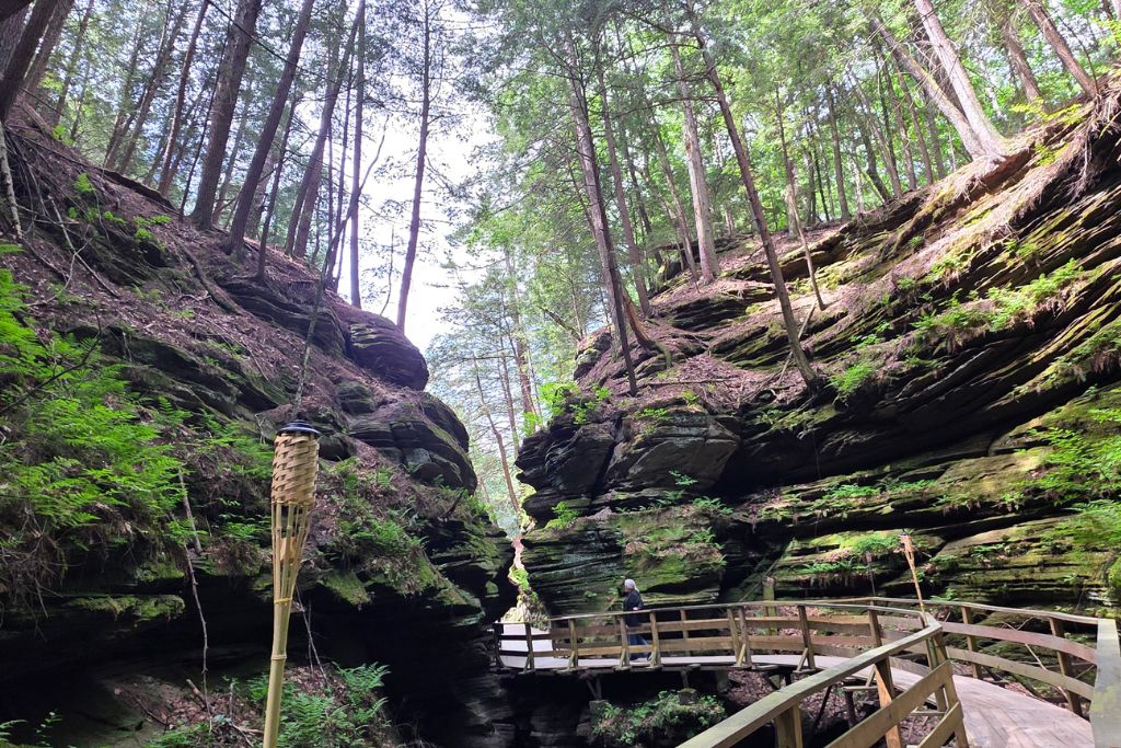 Wisconsin Dells For Adults: Beyond The Waterparks 4 Wooden boardwalk winds between towering moss covered sandstone cliffs at witches gulch in wisconsin dells.