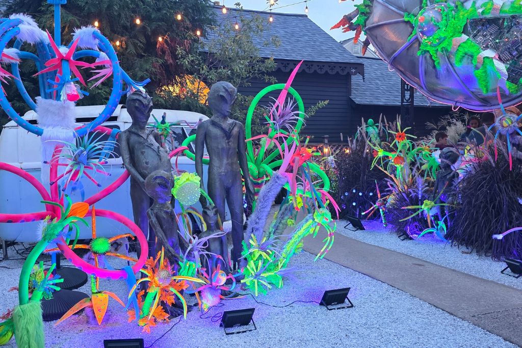 New Hope And Lambertville Fall Day Trip Guide 14 Gray alien figures stand among glowing neon plants and colorful tentacles in a halloween display at under the moon in lambertville.