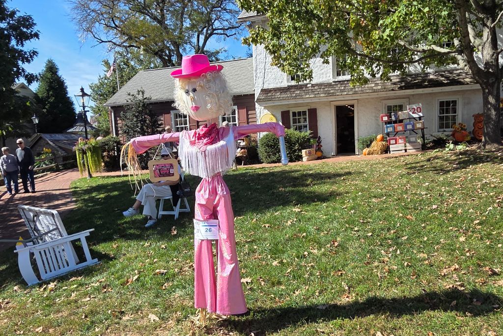 New Hope And Lambertville Fall Day Trip Guide 5 Dolly parton inspired scarecrow wears a bright pink cowboy hat and matching outfit at peddlers village in the fall.