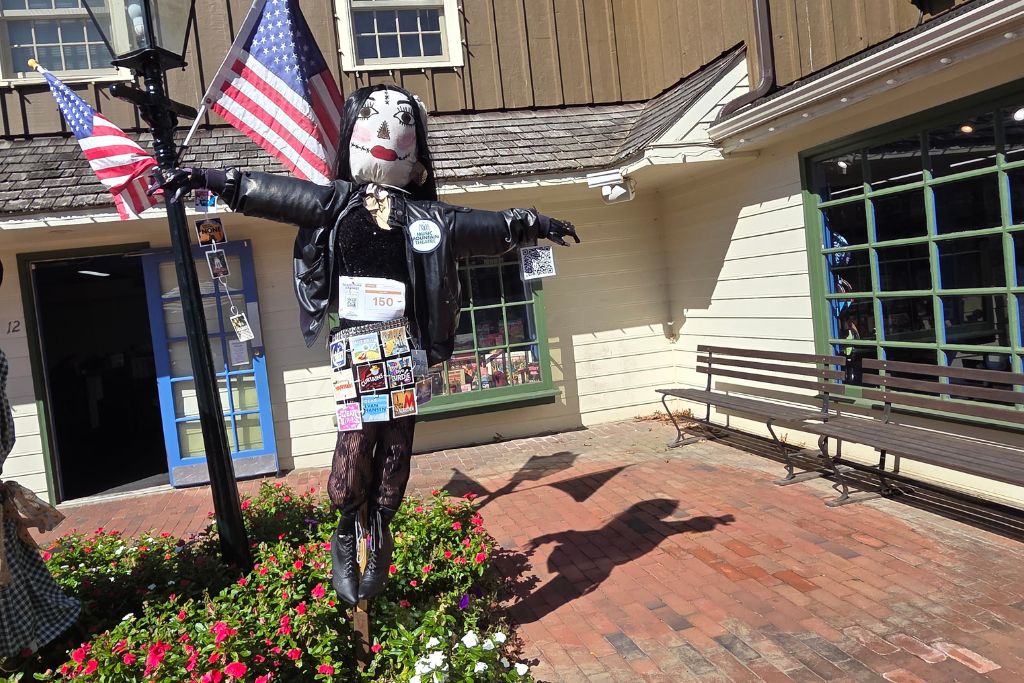 New Hope And Lambertville Fall Day Trip Guide 3 Two halloween scarecrows dressed as a witch and a dark robed figure stand outside shops at peddlers village.