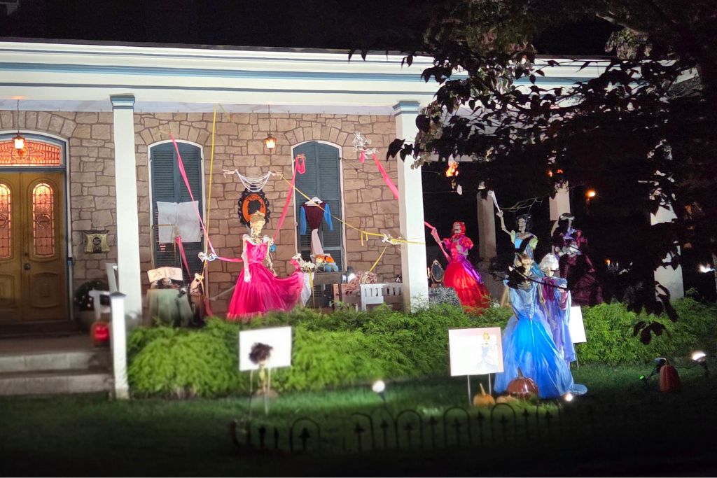 New Hope And Lambertville Fall Day Trip Guide 17 Historic stone house in lambertville decorated with colorful ghostly figures in red and blue dresses for halloween at night.