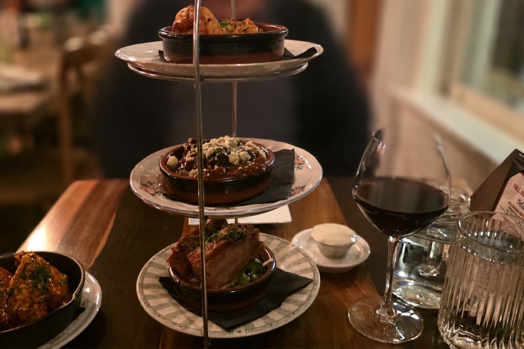 New Hope And Lambertville Fall Day Trip Guide 15 Three tier tapas tower with small plates of savory dishes sits on a restaurant table beside a glass of red wine in lambertville.