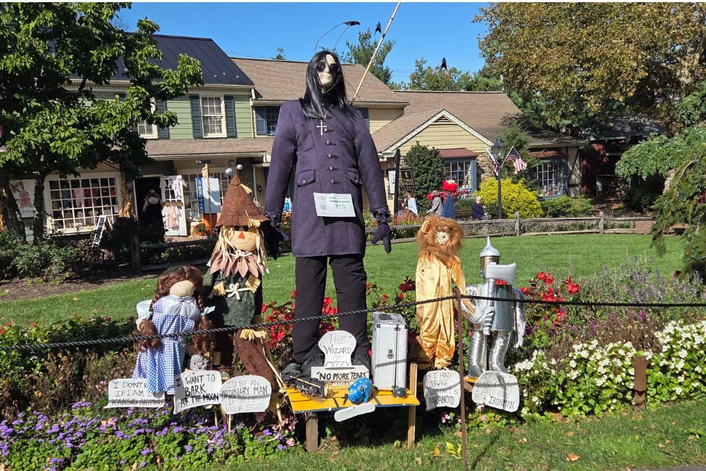 New Hope And Lambertville Fall Day Trip Guide 4 Wizard of ozzie scarecrow display at peddlers village features ozzy osbourne alongside wizard of oz characters in a flower bed.