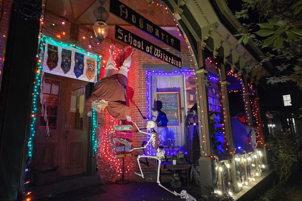 School Of Wizardry Halloween Display In Lambertville, Nj Colorful halloween lights, floating witch, and skeletons decorate a school of wizardry storefront in lambertville, nj.